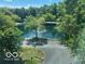 Scenic community pond view framed by lush green trees, showcasing tranquil outdoor space at 8577 One W Dr # 301, Indianapolis, IN 46260
