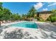 Outdoor pool with a spacious deck and lounge chairs, surrounded by a tennis court and a multi-story condo building at 8577 One W Dr # 301, Indianapolis, IN 46260