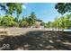 Tennis court next to an outdoor pool, surrounded by trees and community buildings under a sunny sky at 8577 One W Dr # 301, Indianapolis, IN 46260