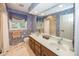Traditional bathroom featuring double sinks, floral wallpaper, decorative mirrors, and a well-lit vanity area at 12602 Lockerbie Cir, Carmel, IN 46033