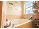 Close up of soaking tub in bathroom with tiled wall and accent decorations at 1266 Hamilton Dr, Greenwood, IN 46143