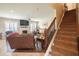 View of a carpeted staircase leading up from the living room, featuring hardwood floors and natural light at 1266 Hamilton Dr, Greenwood, IN 46143