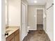 Well-lit bathroom featuring a modern vanity, toilet, and an open doorway leading to a walk-in closet at 14373 Orange Blossom Trl, Fishers, IN 46038