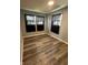 This bedroom features hardwood floors, neutral colored walls and two windows with dark curtains at 2907 Baltimore Ave, Indianapolis, IN 46218