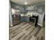 Updated kitchen with gray cabinetry, stainless appliances, and sleek laminate flooring at 2907 Baltimore Ave, Indianapolis, IN 46218