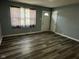 Living room showcasing wood-look flooring, gray walls and a window for natural light at 2907 Baltimore Ave, Indianapolis, IN 46218