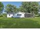 Exterior of home shows a well-maintained backyard with an enclosed screened porch and plenty of green space at 3120 S Meridian Rd, Greenfield, IN 46140