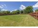 Expansive, fenced backyard featuring lush green grass and mature trees for a private outdoor retreat at 3624 Newberry Rd, Plainfield, IN 46168