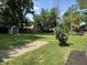 Large backyard featuring a small shed, gravel pathway, and mature trees at 4106 N Sherman Dr, Indianapolis, IN 46226