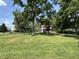 View of the backyard showing the home with lots of trees, mature foliage and a grassy lawn at 4106 N Sherman Dr, Indianapolis, IN 46226