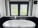 Bright bathroom featuring a luxurious soaking tub and decorative black and white tile at 4106 N Sherman Dr, Indianapolis, IN 46226