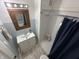 Well-lit bathroom featuring a vanity with a sink and a shower with blue tiled walls at 4106 N Sherman Dr, Indianapolis, IN 46226