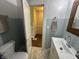 Bathroom featuring a toilet, vanity with a sink, and blue tiled walls with a doorway leading to the hallway at 4106 N Sherman Dr, Indianapolis, IN 46226