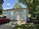 Garage exterior featuring a roll-up door and side door, with a car parked alongside at 4106 N Sherman Dr, Indianapolis, IN 46226