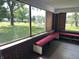 Bright sunroom featuring red benches, brick accents, and large windows with outdoor views at 4106 N Sherman Dr, Indianapolis, IN 46226