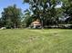 Expansive green front yard of the home surrounded by mature trees under a clear sky at 4106 N Sherman Dr, Indianapolis, IN 46226