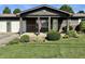 Inviting covered porch with an American flag, brick accents, and established landscaping at 474 N Kristi Rd, Martinsville, IN 46151