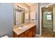 Well-lit bathroom with a vanity, sink, and a large mirror; conveniently located near a hallway at 524 Concord Ct, Fishers, IN 46038