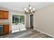 Bright dining room with gray wood floors, stylish chandelier, and sliding glass doors to the outdoor deck at 524 Concord Ct, Fishers, IN 46038