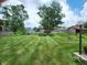 Expansive backyard featuring manicured lawn and wooden shed, creating a serene outdoor space at 6623 Lakeknoll Dr, Indianapolis, IN 46220