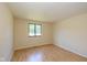 This bedroom features a window, light hardwood floors, and neutral walls at 6623 Lakeknoll Dr, Indianapolis, IN 46220