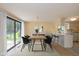 Dining room with large windows and sliding glass doors to back, and view into the kitchen at 6623 Lakeknoll Dr, Indianapolis, IN 46220
