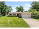 Charming single-story home with a well-manicured lawn and attached two-car garage at 6623 Lakeknoll Dr, Indianapolis, IN 46220