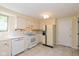 Kitchen with white cabinets, countertops and appliances, tiled flooring, and a window over sink at 6623 Lakeknoll Dr, Indianapolis, IN 46220