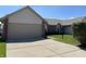 Charming home with a two-car garage, neat landscaping and concrete driveway on a sunny day at 7259 Registry Dr, Indianapolis, IN 46217