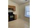 Bright eat-in kitchen featuring classic oak cabinets, tile flooring and modern black appliances at 7259 Registry Dr, Indianapolis, IN 46217