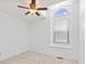 Bright, minimalist bedroom with a ceiling fan, and a large arched window that brings in ample natural light at 7384 Southern Lakes Dr, Indianapolis, IN 46237