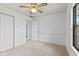 This bedroom offers a ceiling fan, neutral walls, and carpet with a closet and window at 7384 Southern Lakes Dr, Indianapolis, IN 46237