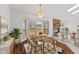Well-lit dining room featuring wood floors, fireplace, deck access, and a stylish chandelier at 7384 Southern Lakes Dr, Indianapolis, IN 46237