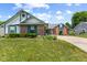 A well-maintained home featuring a brick and vinyl exterior with a green lawn, manicured landscaping, and curved driveway at 7384 Southern Lakes Dr, Indianapolis, IN 46237