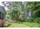 Backyard featuring a grassy lawn with mature trees, a small patio set, and a wooden fence at 7780 Cree Trl, Indianapolis, IN 46250