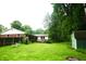 A serene backyard view, showcasing a well-maintained lawn, a cozy deck, and mature trees for privacy at 7780 Cree Trl, Indianapolis, IN 46250