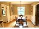 Cozy dining room with hardwood floors, wainscoting, a chandelier, and a view into the kitchen at 7780 Cree Trl, Indianapolis, IN 46250
