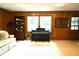 Living room featuring wood-paneling, a piano, carpet flooring, and a built in bookshelf at 7780 Cree Trl, Indianapolis, IN 46250