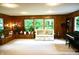 Spacious living room with wood paneling, large windows and a cozy couch. The piano is included too at 7780 Cree Trl, Indianapolis, IN 46250
