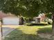 Charming brick home with a two-car garage and a well-manicured lawn, shaded by a mature tree at 8092 Crystal Ct, Avon, IN 46123