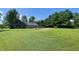 Expansive grassy backyard with mature trees, a seating area with a fire pit, and a glimpse of the house at 8829 Tracy Dr, Clayton, IN 46118