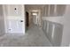 Hallway with drywall ready for final touches, showcasing access to various rooms and a glimpse of the exterior at 9417 Crimson Cir, Lapel, IN 46051
