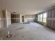 Large open-concept living room with windows and access to outdoor area, with drywall installed on the walls at 9417 Crimson Cir, Lapel, IN 46051