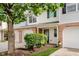 Charming townhome featuring an attached garage, green door, and well-maintained landscaping at 9689 Exchange St, Fishers, IN 46038