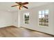 Clean, bright living room with wood floors, two windows and a classic ceiling fan at 10658 Pavilion Dr, Indianapolis, IN 46259