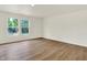 Bright, airy living space with wood floors and two windows showcasing backyard at 10658 Pavilion Dr, Indianapolis, IN 46259