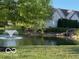 Peaceful view of a pond featuring a fountain, stone landscaping and manicured lawn at 11503 Winding Wood Dr, Indianapolis, IN 46235