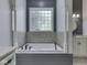 Luxurious bathroom featuring a large soaking tub with decorative columns and tiled walls, plus a granite vanity at 3270 Cherokee Cir, Bargersville, IN 46106