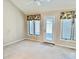 Bright bedroom featuring a vaulted ceiling, carpet flooring, and a glass door for natural light at 3400 W Riggin Rd, Muncie, IN 47304
