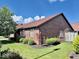 Brick home featuring landscaped yard, mulch beds, and a well maintained lawn at 3400 W Riggin Rd, Muncie, IN 47304